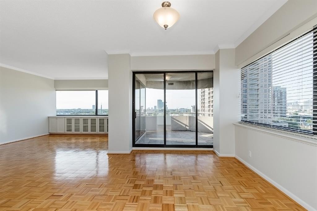 Reverse view of the kitchen featuring its fine crown decorative molding and custom blinds. This space overlooks the spacious balcony through the glass sliding doors.