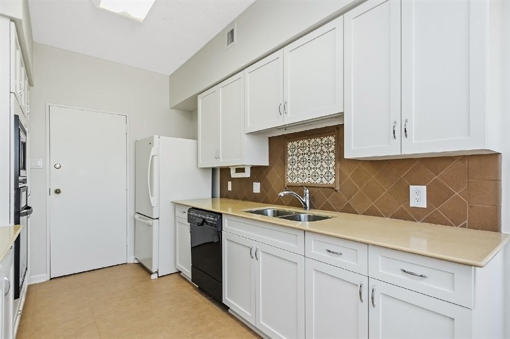 A closer look at the custom built-in storage spaces. This kitchen is well laid-out with the location of the sink, oven, and refrigerator, leading to a generously proportioned pantry area.