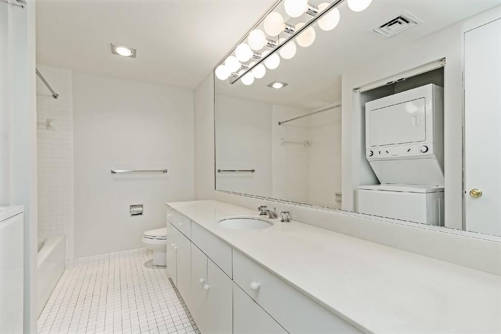 This one-of-a-kind bathroom boasts of a separate tub and a shower, with a white subway tile surround. It features a lovely vanity, oval sink, and designer lining, emanating a very crisp and clean look.