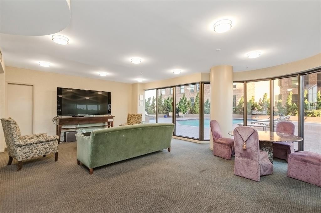 Infinite entertainment opportunities await you both indoors and outdoors in this condominium. This media room contains a sofa, lounge chairs, coffee table, an area rug, and an entertainment center. Sun or shade, in any season -- it is easy to find happiness in this place.