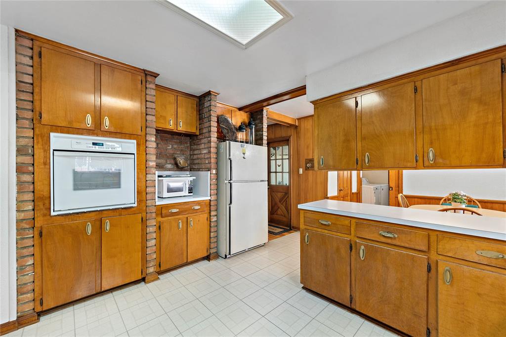 The perfectly structured pantry and fully equipped appliances put together enchanting mornings with a calming vibe. The deliberate arrangement of the appliances and cabinets ensure a pristine kitchen.