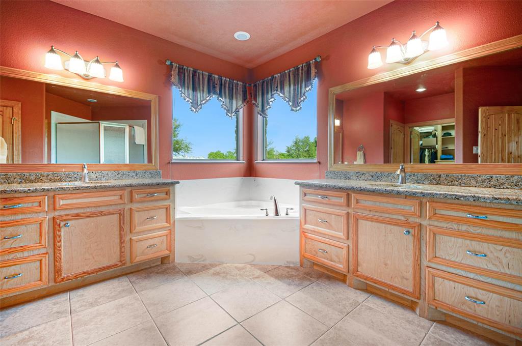 Luxurious baths can be had in this garden tub surrounded by the quality of custom building that continues in the master bath with custom vanities with granite tops, custom framed mirrors, garden tub and 20