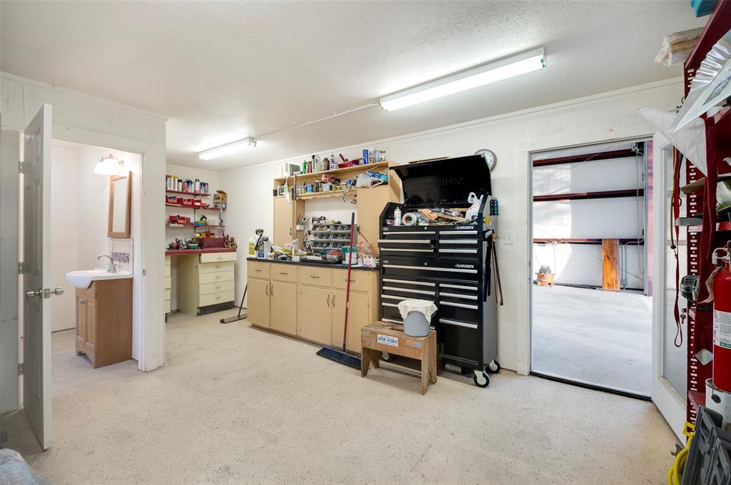 Extra-sized garage has separate workshop and full bath area with tiled stall shower. *Only cold water but plumbing & electrical hookups for hot water are in place.