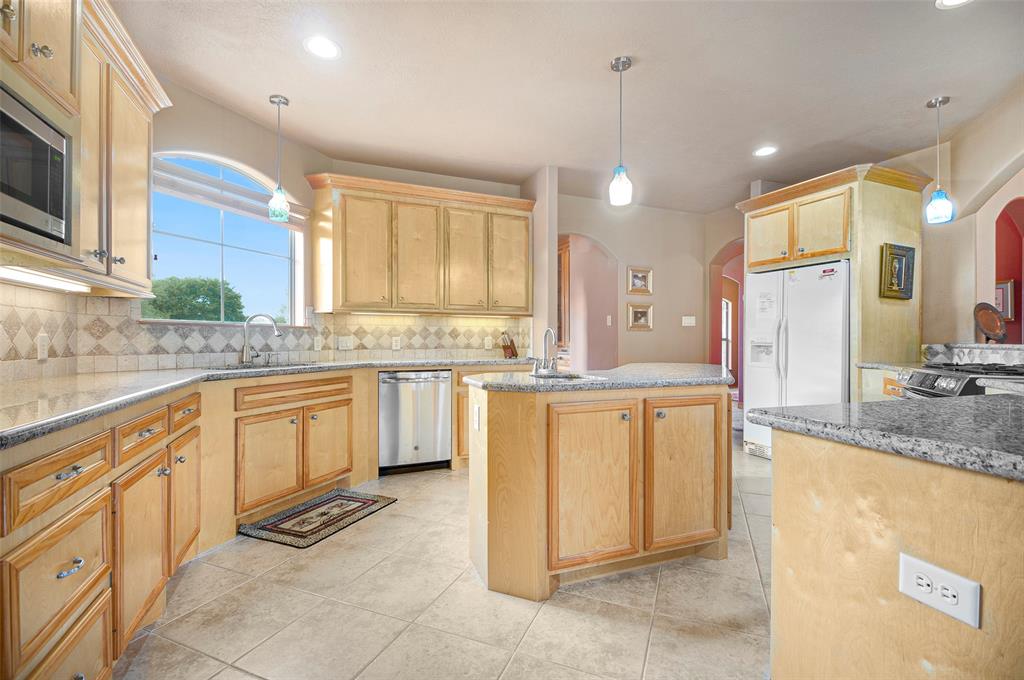 More to love in this beautiful kitchen - custom cut-in baseboards, tiled backsplash throughout, contrast wood-stained cabinet trim, stainless steel appliances (refrigerator does not convey).