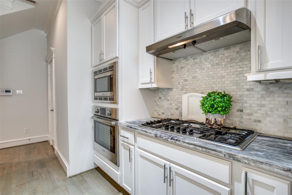 Stainless steel appliances include the microwave, oven, cooktop, vent hood and dishwasher.