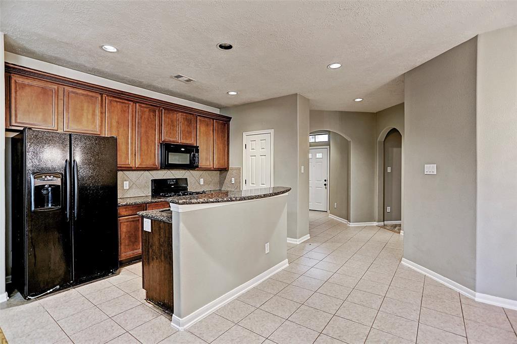 Kitchen offering Granite counters, Gas cooking range, Frig included! Arch way to the right leads to 2 secondary bedrooms and 1 full bath.  ALL PHOTOS ARE FROM A PREVIOUS LISTING