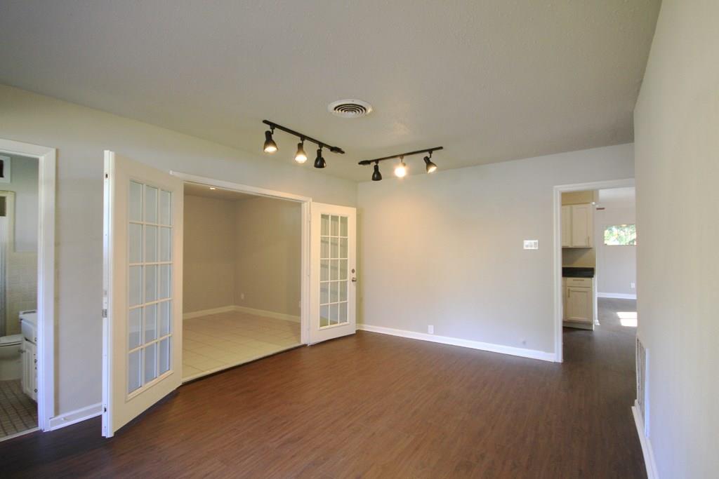 Family room at the entrance to the home. Large extra room with french doors could be used as an office or potentially a fourth bedroom. Home features new flooring throughout the living spaces
