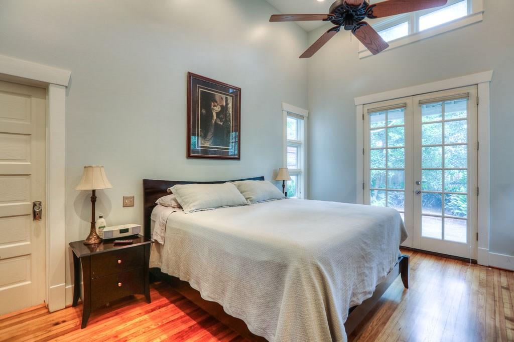 Large master bedroom with soaring ceiling features built-in storage and a large walk-in closet.