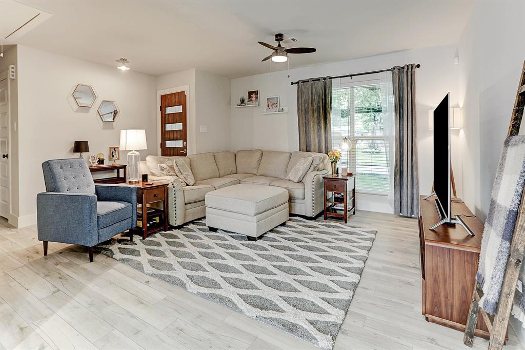 Open living space features neutral paint, beautiful wood tile floors and new ceiling fan.