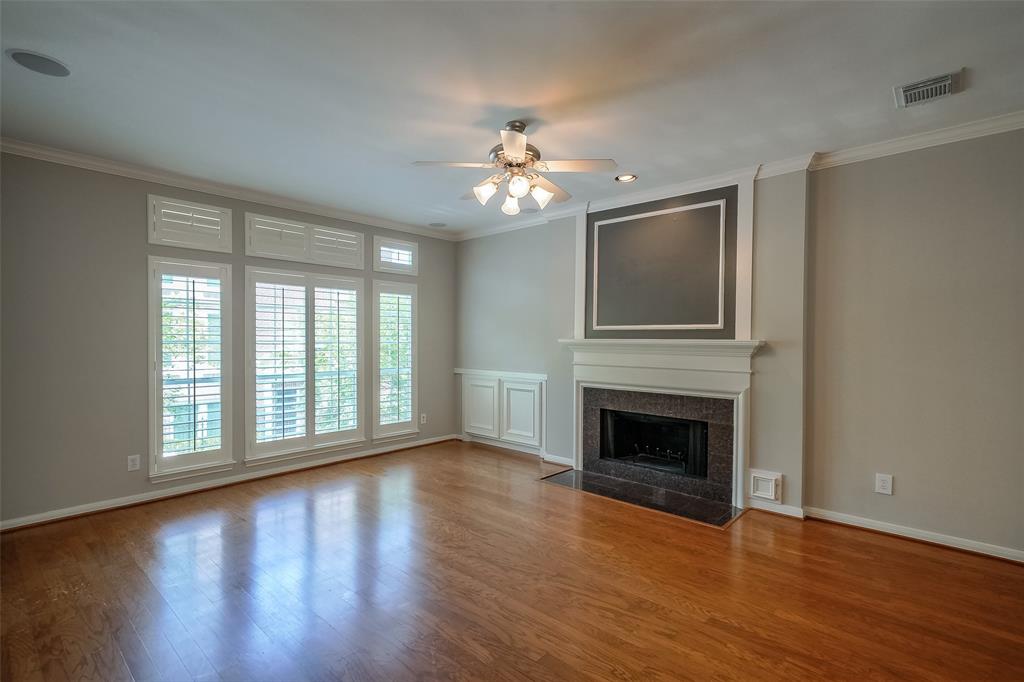 Light-filled living room with gas fireplace and plantation shutters. A perfect space for any season!