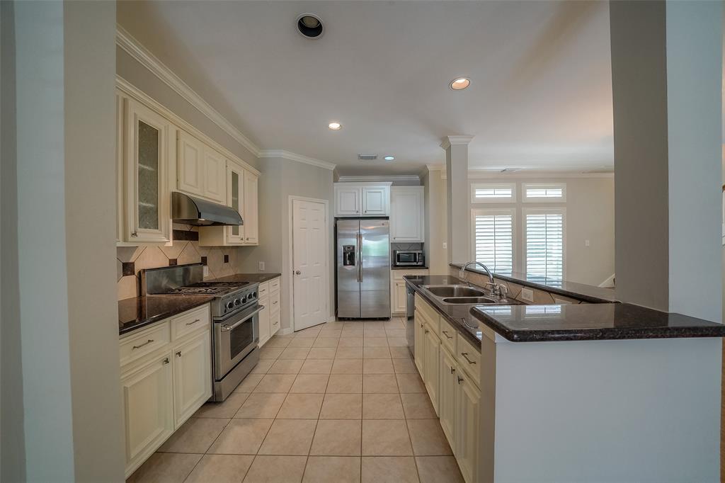 Open concept kitchen with stainless steel appliances and granite countertops. Refrigerator was recently updated. Includes microwave and professional grade gas range.