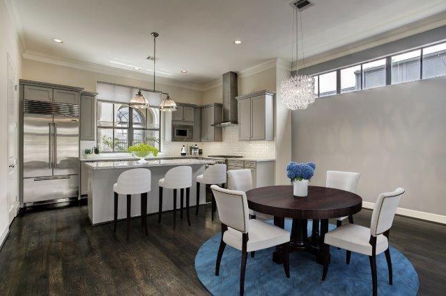 The second floor living level has ample space for a dining set up, and the kitchen includes a custom installed Sub-Zero fridge plus an island with overhang for seating (all virtually staged).