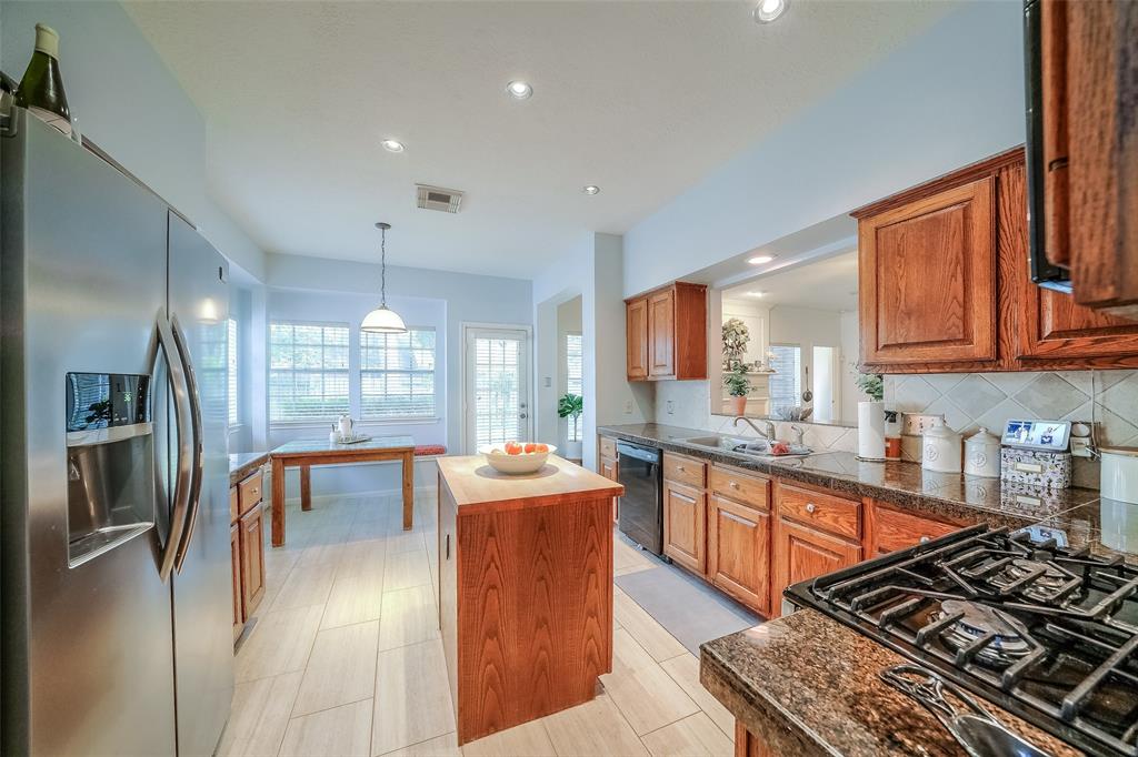 Spacious Kitchen includes granite countertops, butcher block island, and breakfast nook with cozy, custom cushioned window seating.