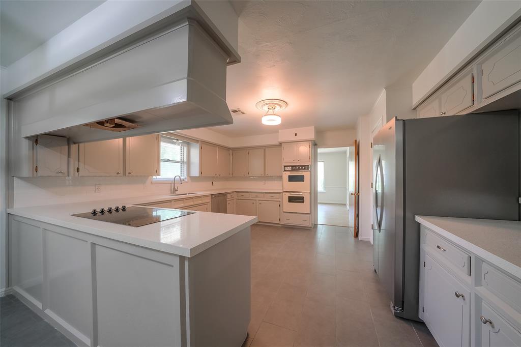 The updated kitchen features quartz counter tops, new tile floor and new stainless steel appliances.