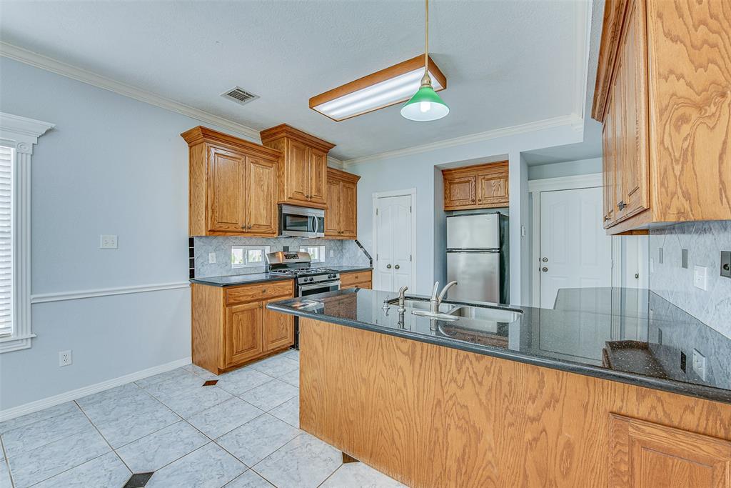 The kitchen features black granite countertops and solid wood cabinets.