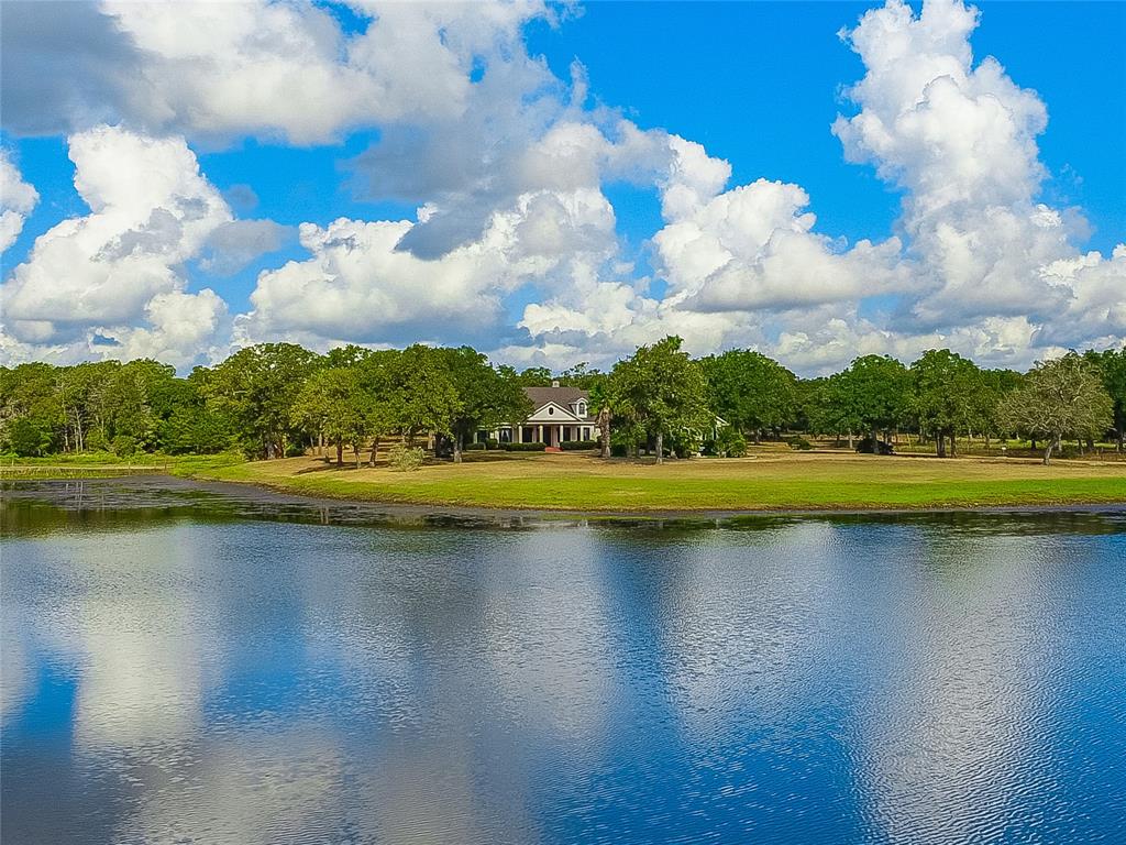 392 Fm 2104 Smithville, Texas 'The Parker Ranch - Los Robledos' ~ Gorgeous ranch (291.07acres) outside of Smithville with stately entrance and lakefront setting nestled among an abundance of beautiful scattered oaks. Custom designed home with quality finishes including library paneling, built-ins and cabinetry. Main residence is 3410sf (3BR/3BA) and Guest home is 1215sf (3BR/1BA) per BCAD. There are large stocked ponds and additional storage/utility buildings near the guest home. Property is conveniently located between Highways 290 and 71.