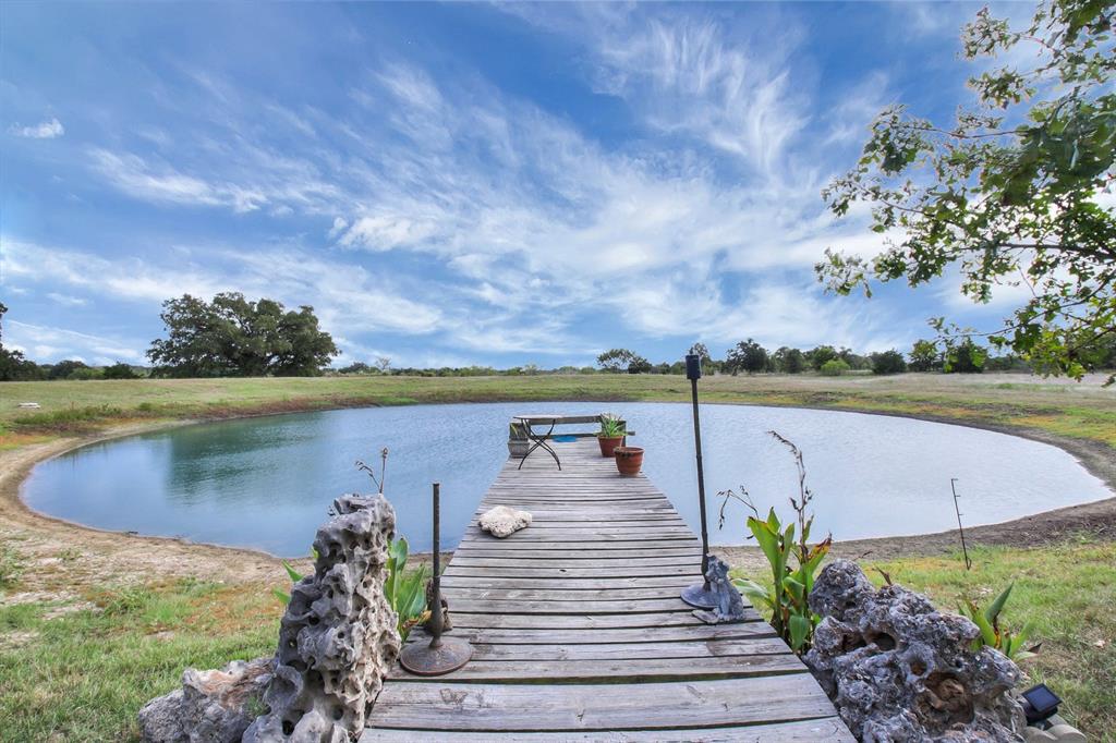 146 Lexington Road McDade, Texas DREAMS DO COME TRUE on this 42 +/- ac farm with unique, barn-style home. 5000 +/- SF family home hosts TWO complete living areas: Main is 2400 SF 4B/2B, the shared laundry room with full bath connects both living spaces with garage access. In-law suite features 1200 +/- SF with 2B/1B. 1400 +/- SF workshop has two 14X14 roll-up doors. The unfinished loft above includes a 12X30 deck for sunset viewing. Outbuildings for RV, animals, hay, etc. Irrigated, 9 +/- ac. hay field and 20 +/- acre pasture.