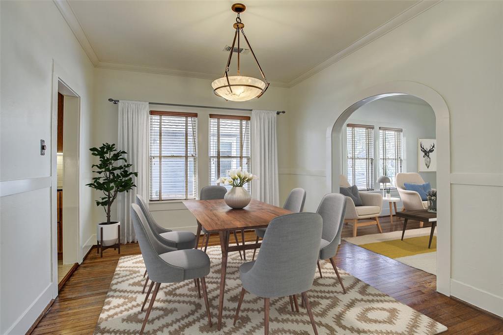 The dining room readily fits a 6-8 person dining table. The hall leading to the first floor bedrooms and full bath is behind the photographer.  Living room to the right and kitchen to the left.  (This room has been virtually staged.)