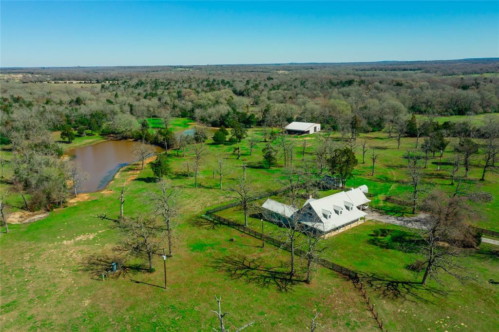 15146 W Highway 7 Marquez, Texas This 90+/-acre ranch is the ultimate recreational property equipped w/ outstanding improvements & endless opportunity. Nestled in western portion of Leon County, The Walston Ranch fronts Hwy 7 in Marquez & is only 14 miles from I-45 & Centerville. Upon entering the property on the asphalt driveway, you are greeted with beautiful +/-3,000 sf homestead. The wraparound porch offers a great sitting area overlooking the large stock tanks & rolling topography. The land is 80% wooded with combination of pastures & scattered trees at the front. The back portion offers three cleared lanes providing great access w/ spectacular hunting & recreational opportunities. Other improvements include a 85’X60’ barn w/ tack room & working pens. Great access with over 1,360’ of road frontage and two gates/entry points off Hwy 7. This tract checks every box, great move in home site with mature scattered trees & separate secluded recreational areas. Properties like this truly don’t hit the market very often.