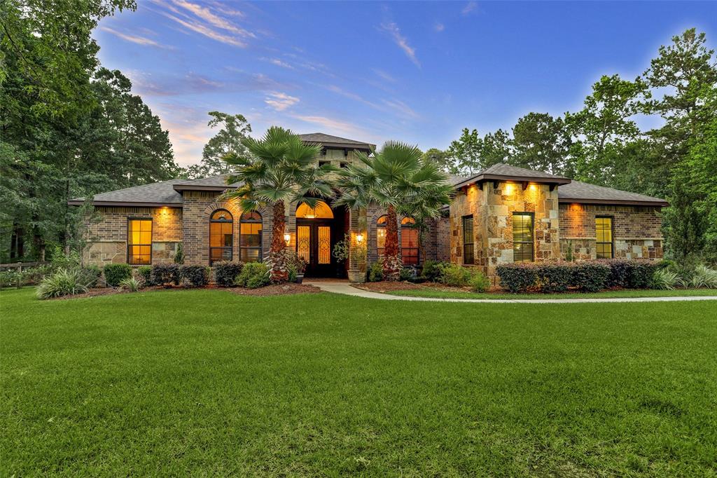 12310 Pin Oak Drive Magnolia, Texas Exquisite, custom one-story built by highly acclaimed Dunn & Stone Builders is nestled on stunning 2 acres and boasts high-quality finishes, including exposed beams, stone accent walls, epoxy garage flooring and radiant barrier. Gorgeous island kitchen offers granite countertops, 5-burner gas cooktop, SS appliances, abundant cabinetry, massive breakfast bar & walk-in pantry. Kitchen opens to breakfast nook and impressive living area w-soaring, stone floor-to-ceiling fireplace & amazing sliding patio doors for desirable indoor–outdoor living. Luxurious master features wall of windows providing spectacular views, private access to the backyard, sitting area, huge walk-in shower & his/her closets. Upgrades galore include 3 guest beds w-en suite baths, game/media, formal dining, handsome study w-French doors, wine/dry bar, extensive covered patio plumbed for summer kitchen & oversized 3-car garage. Enjoy deer & other wildlife roaming in backyard. Superb schools, 3 septic tanks, low taxes.