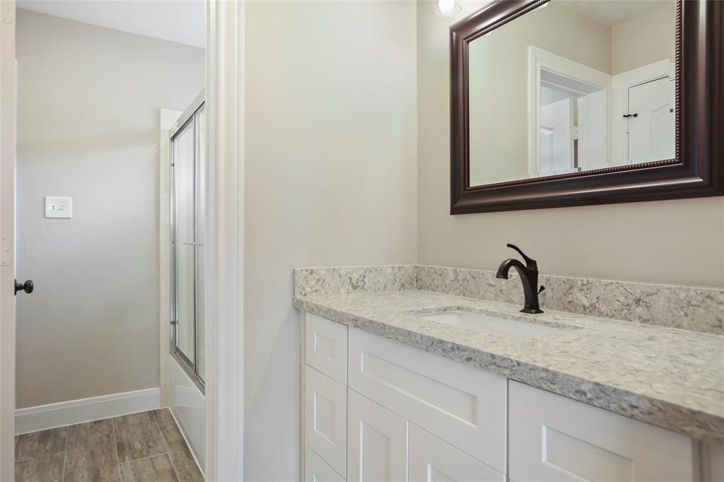 This is the first secondary bedroom's lavatory.  Nothing skimped here, all the restrooms feature the same high quality porcelain flooring, shaker cabinets and quartz stone countertops and beautiful hardware.