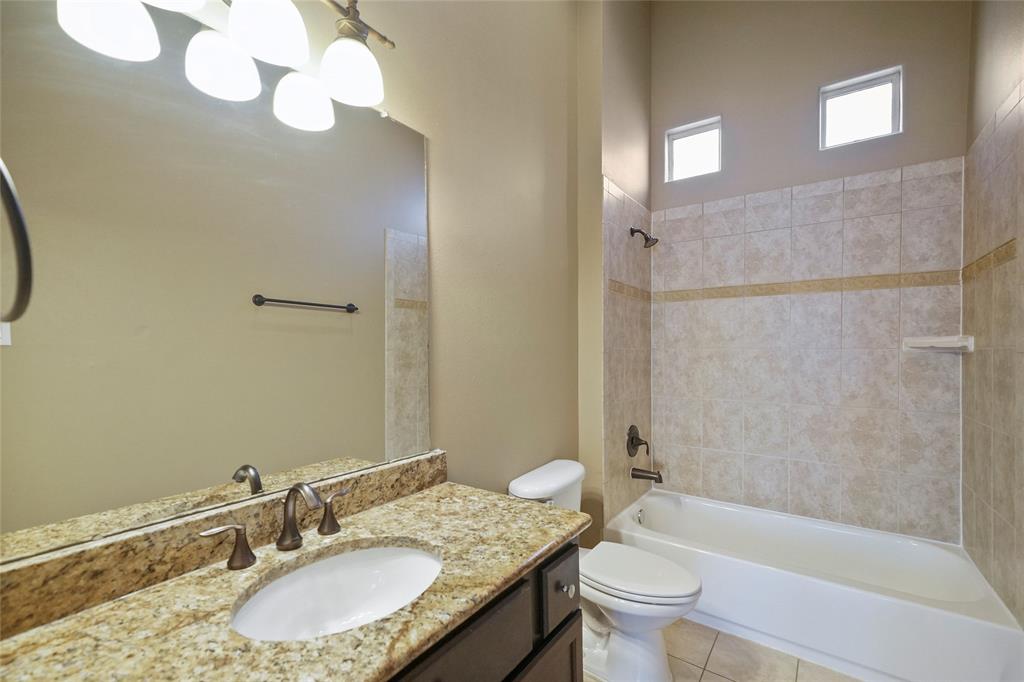 The secondary bathroom includes tile surround and floors. It also includes a vanity with great storage and granite countertops.