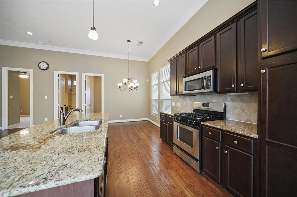 The island kitchen includes stainless steel appliances, granite countertops, and tons of cabinet space.