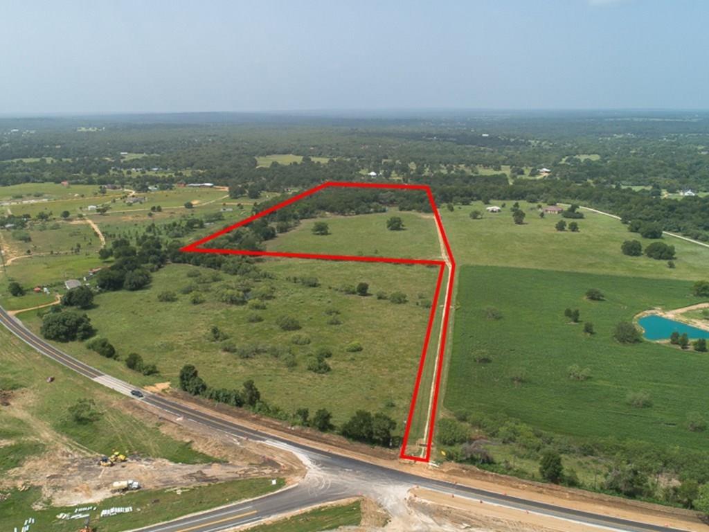 1558 SH 304 Smithville, Texas A Little Slice of Heaven! ~ Beautiful 25 acres with park-like setting, gorgeous grove of oaks, trails, pasture, & a stocked pond with black bass & perch. Creek frontage at the back of property which is a tributary of Sandy Creek. AG Exemption currently in place for cattle lease. Aqua Water & Bluebonnet Electric meter present with buried lines ready for your site-built custom home! Property is fully fenced & cross-fenced with mesh horse fencing & has an automatic gate entrance & a proud Texas flag to welcome you. Deeded easement. The shipping container does not convey.