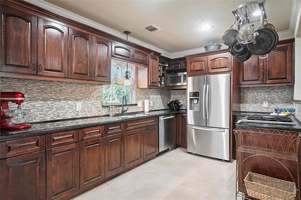 Gleaming kitchen with SS appliances, cabinets galore, natural light, granite countertops & custom backplash.