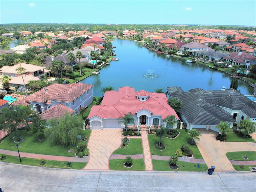 18718 Windsor Lakes Drive Houston, Texas Pristine, custom-built Mediterranean-style lakefront home with breathtaking views! This 1.5 story home offers 3 bedrooms down, plus a gameroom and half bath up. Impressive attention to detail throughout and superbly maintained. Elegant foyer with double mahogany doors and dramatic rotunda with 23-foot ceilings. Distinguished Old World style study painted with 14K gold paint. Large island kitchen with under/over counter lighting, granite counters, lots of drawers, cabinets and counter space, a triple sink, Jenn-Air gas stovetop and grill with downdraft, double ovens, warming drawer, and separate wine bar. All with an open view of the living with gas fireplace and built-ins. Impressive owner’s retreat with double-tray ceiling and spacious sitting area with tranquil views of the lake. Step outside onto the gorgeous Mediterranean multi-arched veranda offering stunning views. Enjoy added peace of mind with your whole house generator. Make cleaning easy with your built-in vacuum system.