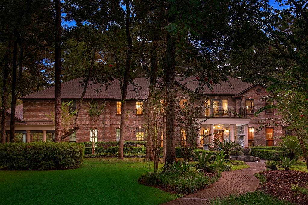 37502 Pinwood Court Magnolia, Texas Majestic custom home on 6.77 lush acres at the end of a quiet cul-de-sac in Wildwood Estates! This home borders a nature reserve on 3 sides that will never be developed! Gated entry, covered front porch, dual Honduran mahogany entry doors with beveled glass, sweeping staircase, detailed trim work, solid Rosewood floors from Thailand on 1st floor, exotic Merbau hardwoods on 2nd floor, solid pine interior doors, 400+ ft deep private well, and 1 1/4" main water supply line maintains full water pressure. Open concept kitchen with breakfast bar, double oven and walk-in pantry (that doubles as a safe room) overlooks sunny breakfast nook and den; both formals; handsome study with French doors and built-ins; master retreat down with built-in coffee bar, sitting area and cozy fireplace; 4 bedrooms, media and game room up; oversized 3 car garage + 3 car porte-cochere; over 3,000 sf. of exterior slate patios, 400 ft of waterfront access to Old Mill Lake, and sparkling pool with waterfalls.