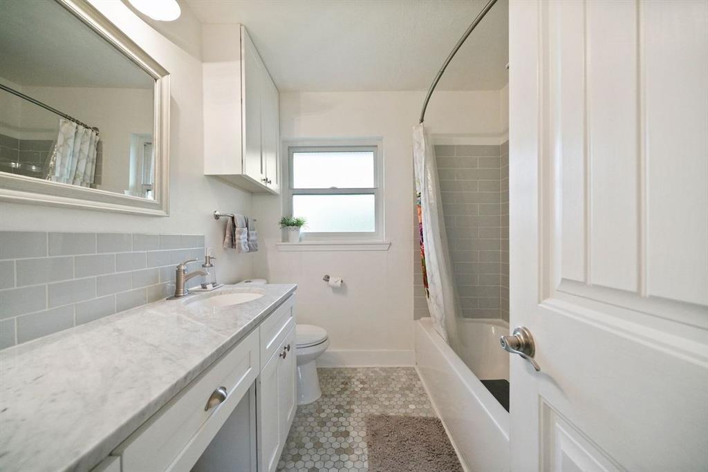 This fresh and airy bathroom features beautiful tile work throughout.