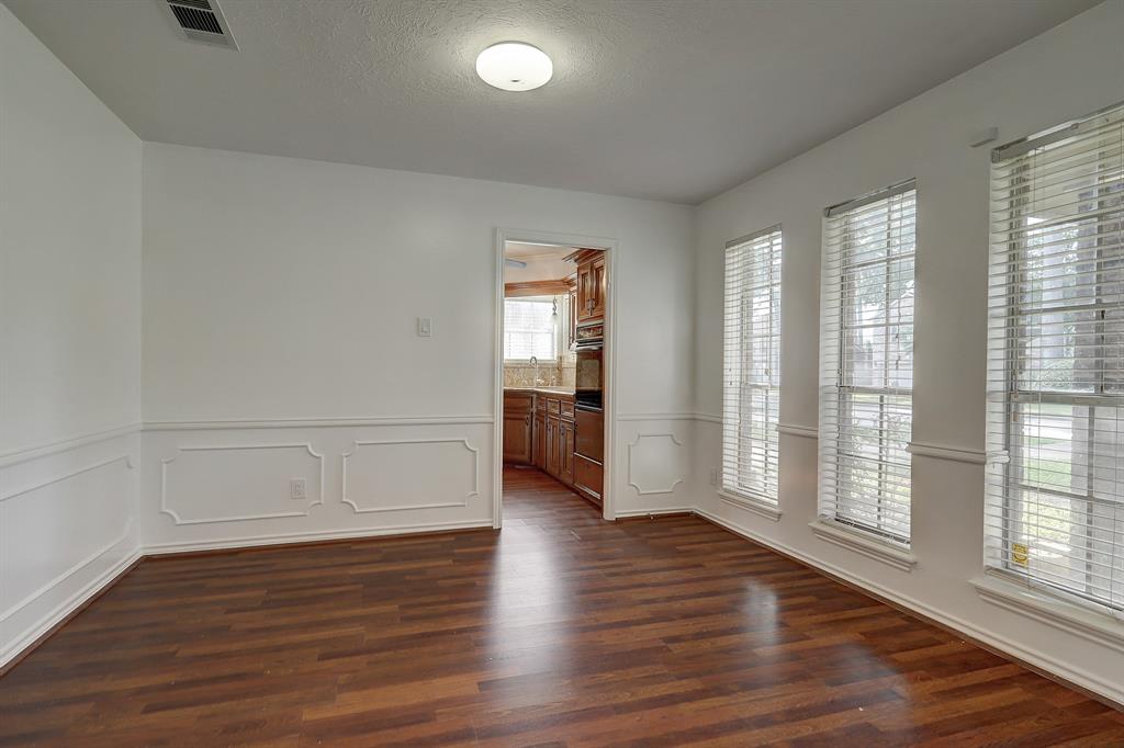 The gracious, formal dining room with chair rail mill work is located off the entry hall and leads to the kitchen.  It looks out on the front yard.