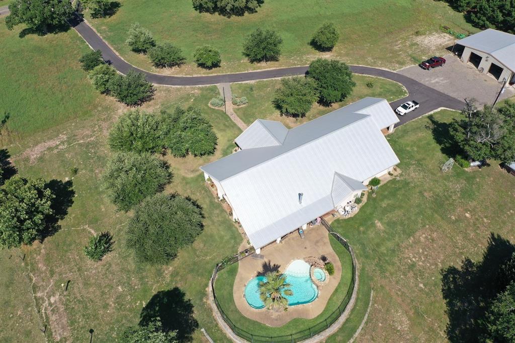 4243 Anderson County Road 403 Palestine, Texas Rare opportunity to purchase a piece of heaven in East Texas. Custom built 3/3 Ranch style home on 35.32 Acres cross-fenced and improved, ready for livestock. Rustic ranch home with soaring ceilings, functional kitchen with granite and premium appliances, open to dining and living room. French doors lead to a full-length covered patio. Gunite pool with hot tub and private office off the master bedroom. Master bath is a must see with propane fireplace, garden tub, and over the top shower. Three car garage with plenty of storage and large metal shop with office, chicken coop, small garden, and cattle pens.