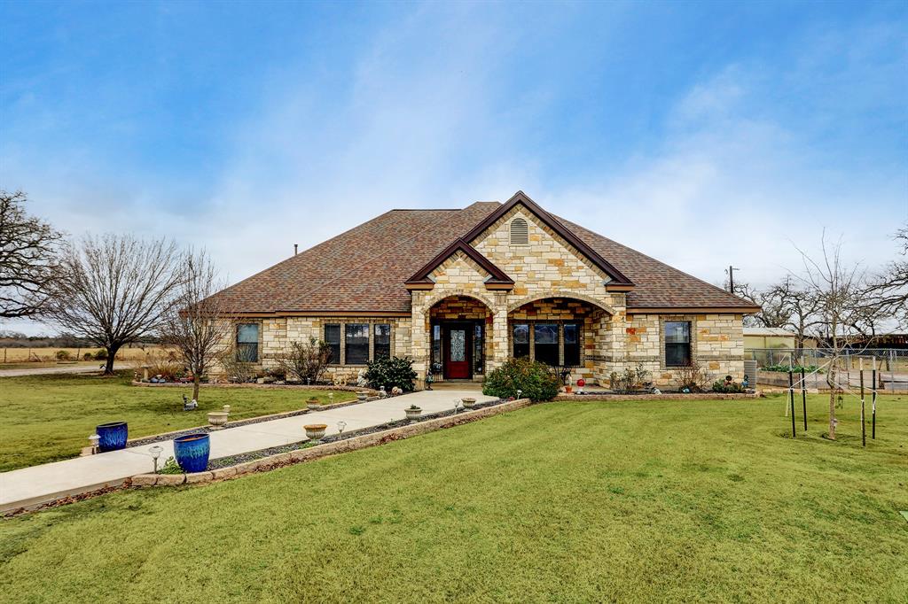 2186 County Road 113 Giddings, Texas Country living on 5 acres not too far from the city. This gorgeous 3285 sf. custom one story home boasts 3 bedrooms, 2 1/2 baths, situated on a quiet road. Spacious foyer with study off entry with glass french doors. Beautiful master bedroom with high ceilings and access to the pool and luxurious master bath with large walk-in closet. Other features include, impressive formal dining room with coffered ceiling, kitchen w/ island and breakfast room open to family room. The family room is highlighted by a stone fireplace and view to the pool. The game room with wet bar and built-ins is a great space for entertaining. Enjoy midnight swims in the sparkling pool or soak in the separate hot tub. Property is fenced for horses with two horse stalls, 30x45’ RV metal bldg. and storage shed. Enjoy growing your own vegetables in the raised beds and greenhouse. This well maintained home has it all.