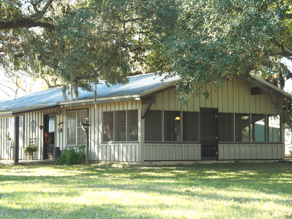 1416 County Road 125 Hallettsville, Texas A quarter-mile of Navidad river frontage, centuries-old oak trees, two ponds, gently rolling terrain set this property apart. A winding tree-lined drive takes you to the main cabin which has been recently updated to include granite countertops in the kitchen and a large walk-in shower in the bath. The open living/dining space features a wood-burning potbelly stove and vaulted & beamed ceilings. A big, screened porch and shady patio are both great places to enjoy the view of the ponds and massive oak trees. Just steps away is a 720 sqft 1 bedroom, 1 bath guest cabin that includes an office area. Other improvements: 1,980 sqft metal workshop with drive through pull-up doors and a concrete floor, horse stalls and paddock, and a Morgan storage building finished with electric and A/C. The property is fenced/cross fenced with a nice mix of improved pastures and wooded areas. This is a weekenders' paradise with bass fishing in the ponds and plenty of wildlife habitat along the Navidad River.