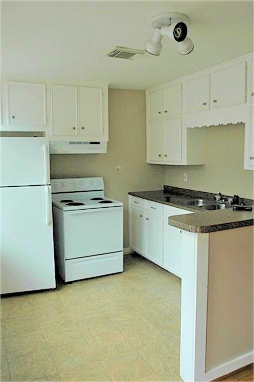 The open kitchen includes a refrigerator and dishwasher, as well as generous cabinet space.  The entry door is to the left just outside the photo.