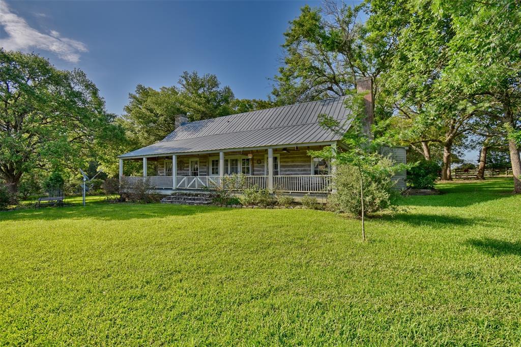 1711 Hwy 237 Road Round Top, Texas Triple Creek Ranch is a piece of Texas history! Whether used as a family compound of B&B, you will find a combination of rugged simplicity & stylish charm. Positioned on 31+/- acres minutes from Round Top, the significantly historic 3BD/5BA home was built in 1825. The walls are made of cedar logs with century old longleaf pine floors. The restoration was documented. The kitchen, with a wood burning fireplace, is cozy and has new granite counter tops. There are also wood burning fireplaces in the large family room and the master bedroom. The property is being offered turnkey. Conveniently located 1.5 miles south of Round Top, drive through the woods to the main home, 1/1 guest house and a separate entertainment cottage w/full kitchen. The property has lovely oak trees, fruit trees and a garden area. A concrete floored 40x40 steel pavilion, 35x30 metal storage barn, fenced and cross fenced pastures for your horses, goats or cows and a chicken coop make this offering a must see!