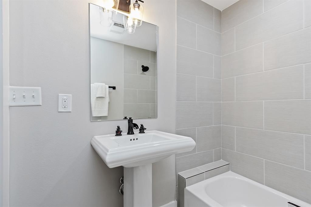 The third full bath with a tub/shower combo is adjacent to the fourth bedroom.