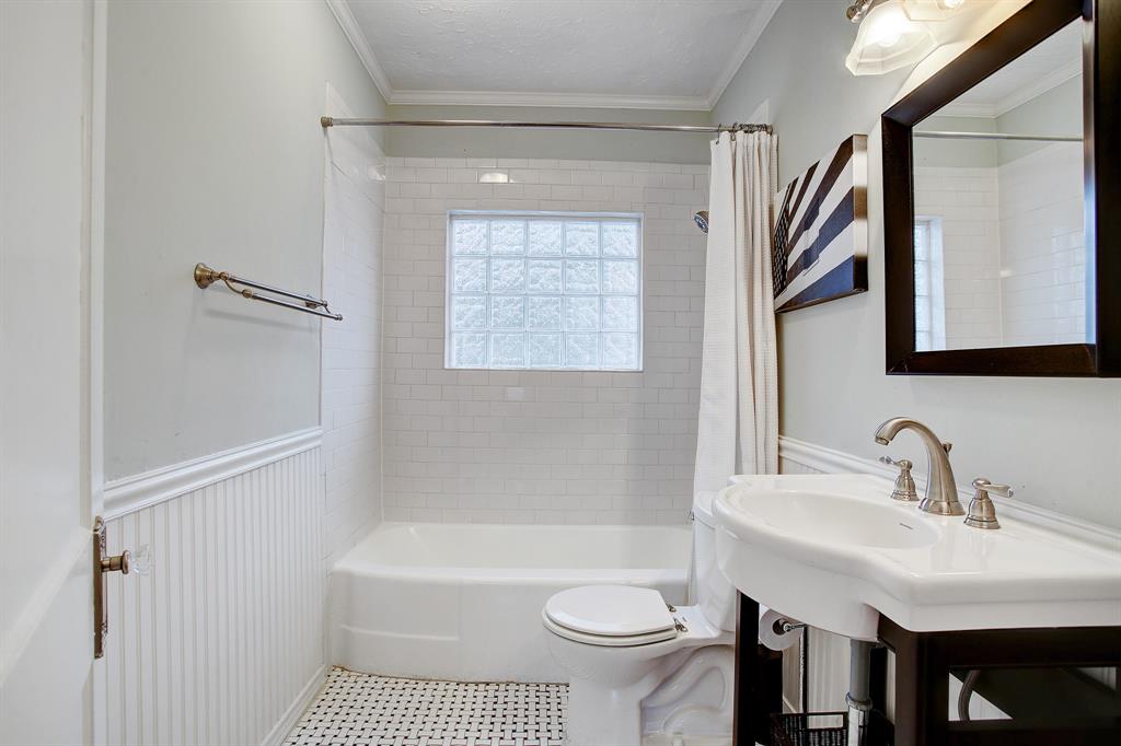 The second full bath updated as thoughtfully as the primary bath, is adjacent to the second bedroom and located off the dining room in the center of the home.  Behind the door is a linen/storage closet with shelves.