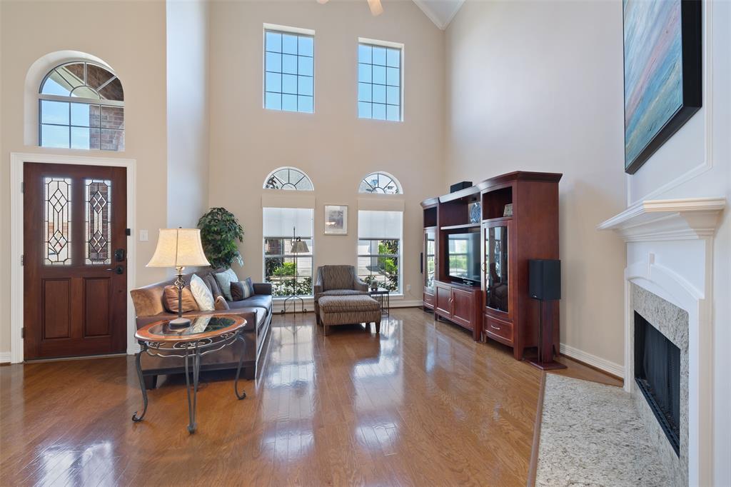 The gracious entry of this home brings you to the living room with a soaring ceiling, wall of windows and a fireplace.