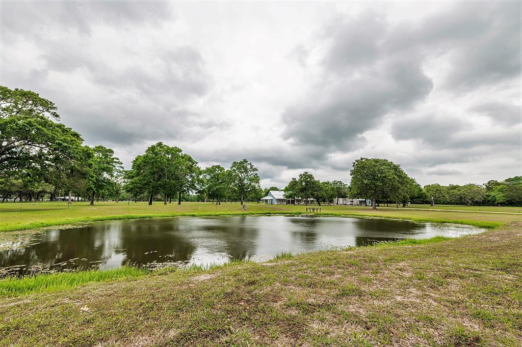 1320 Fm 1890 Columbus, Texas Gorgeous home located on manicured park-like 16.87 acres! This custom country home is nestled between spectacular oak trees w/views of wildlife & lush pastures. Enter into the great room from the front covered porch & you instantly feel warmth, peace and at-home. Gorgeous fireplace is a focal point! The kitchen is a cooks dream- from the large island space to the copper sink, pot filler, convection ovens, storage and large pantry. Split plan w/the grand primary suite on one side & the two secondary bedrooms & bath on the other. The private primary en-suite features large window w/owner retreat area, luxury soaking tub, huge shower, double sinks, and lg closet. The study/office is near the primary and could possibly serve as a 4th bedroom. You will love the mud room, 1/2 bath and spacious utility room. 45X45 metal framed shop w/additl 15X45 covered storage,12X24 she/he shed, stocked pond, & perimeter fenced (field fencing). You have just found your dream country home! Call today!