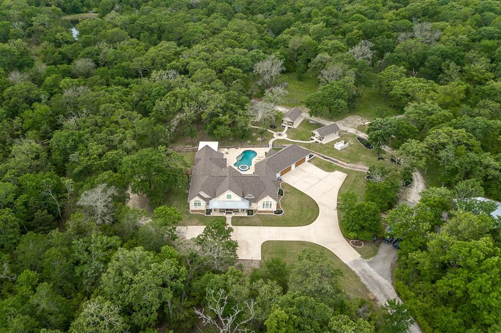9475 Weedon Loop Bryan, Texas One-Of-A-Kind Entertainment Showplace! Custom-built Texas Hill Country style property situated on 20.03 acres, comprises main house, 4 cabins, barn, pool, & hot tub. White limestone & wood embrace the design & exude elegance. Timeless aesthetic features throughout. Heated & Cooled: Main house: 4B/3.5B, 3,922 sf; Guest cabins-3 @ 308 sf, 1 @ 720 sf. w/full baths. Great room-soaring 24' knotty pine ceiling w/trusses & track lighting, fireplace surround-limestone, spectacular limestone architectural features; glass french doors, plethora of windows showcasing back patio, pool, hot tub, the grounds; chef's kitchen; dining room; mstr. ste.-24' cathedral ceiling, split design; mstr. bath-soaker tub, dbl. shwr., lge. walk-in closet; 2 ensuite bdrms., flex rm., 1/2 bath; game room-24' soaring cathedral ceiling, knotty pine walls, tin wainscot, bar; back patio-porches, fire pit, 2 turfed areas; 4 car garage; concrete driveways; barn-30' X 40' w/1/2 bath. Schedule your private tour today!