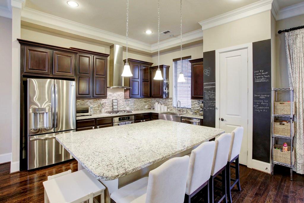 A granite island & breakfast bar anchors the open style kitchen which features high end GE Profile stainless steel appliances and deep single compartment farmhouse sink!