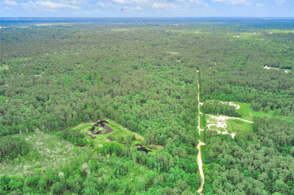 7906 Hodge Lane Montgomery, Texas Retreat style living in Montgomery County. This wonderful lot is ready for you to build your dream home on 33 Acres and offers many opportunities. 3 bedroom split level home with deck. Ponds already stocked with fish and plenty of space for hunting.