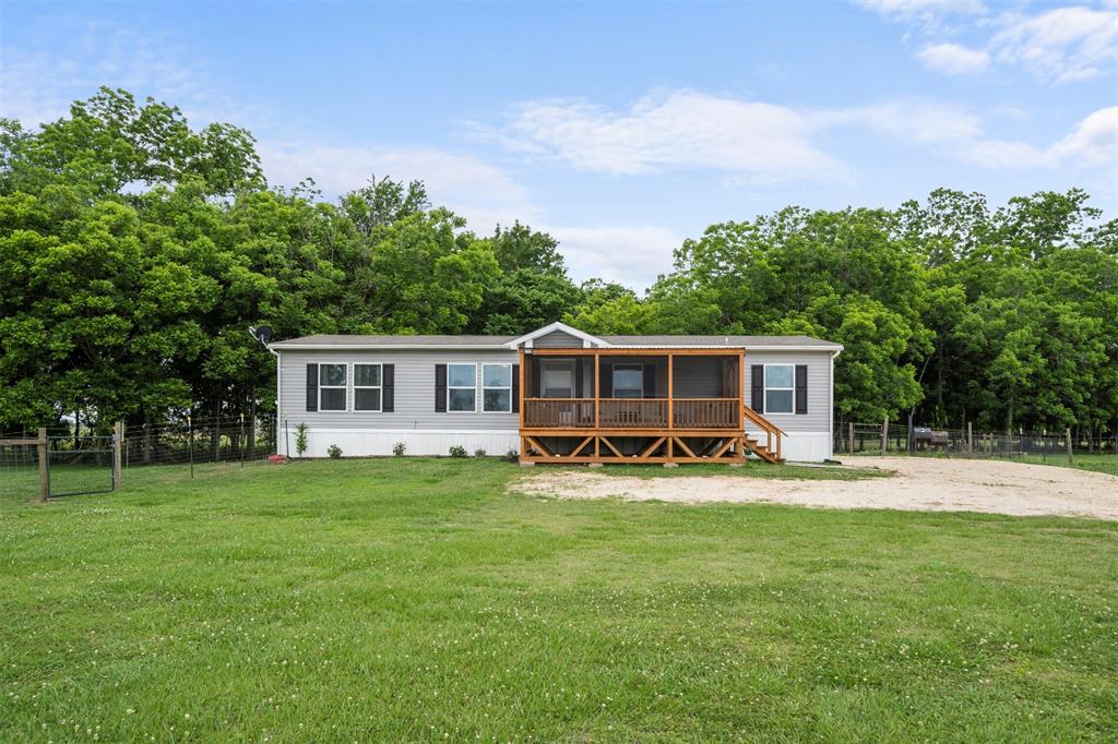 1845 County Road 121 Boling, Texas Find an escape from the hustle and bustle of the city with this amazing 32-acre ranch in Boling. The mostly cleared lot features a charming home with a beamed ceiling, dining room, covered front porch and back patio. The kitchen comes equipped with a range and a walk-in pantry and amazing island. Feel the stress melt away in the relaxing primary suite, complete with a walk-in closet, dual vanities, and tub and separate shower. Spend a quiet afternoon relaxing under the shade of the covered patio overlooking the expansive backyard. Located near highway 288 and highway 6, enjoy easy access to Pearland and Galveston Island. Schools are zoned to Boling ISD. You don't want to miss this home.