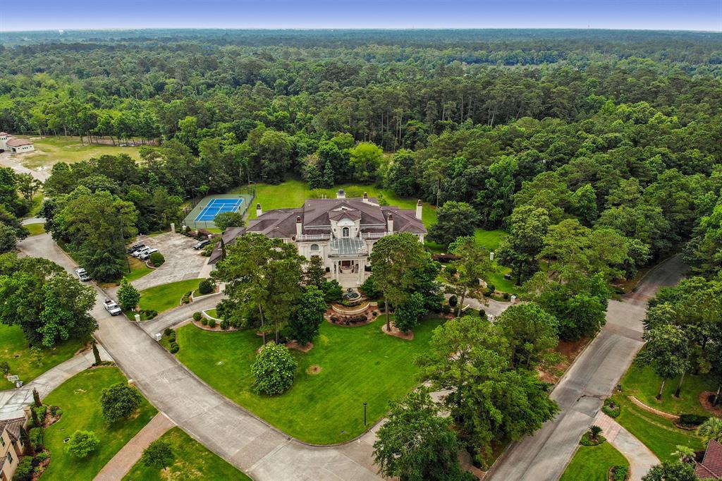 Magnificence of beauty and exceptional design are evident in this iconic Kingwood Estate. Resting on 4 acres peppered with fruit trees, its stately presence is akin to European grandeur with extraordinary craftsmanship noted in colossal dual staircases w/scrolled ironwork balustrades, 7 fireplaces, chandeliers imported from Prague, custom designed architectural ceilings in each room, a gentleman’s trophy room, 2 offices, library, game room, media room and separate apartment. Double height LR has Juliet balcony, exquisite duet of chandeliers, and view of the picturesque grounds, waterfall pool and lighted tennis courts. All rooms are ensconced in designer touches and interlace creating a seamless flow for lavish gatherings. Gorgeous granite-laced kitchen w/ gas cooktop, premium appliances, island & BKFT bar. Opulent primary retreat has dual marble baths. 24 hour manned gated community. 5 minutes to 59 I69, 10 to 99 & 20 to downtown. Crown jewel!
