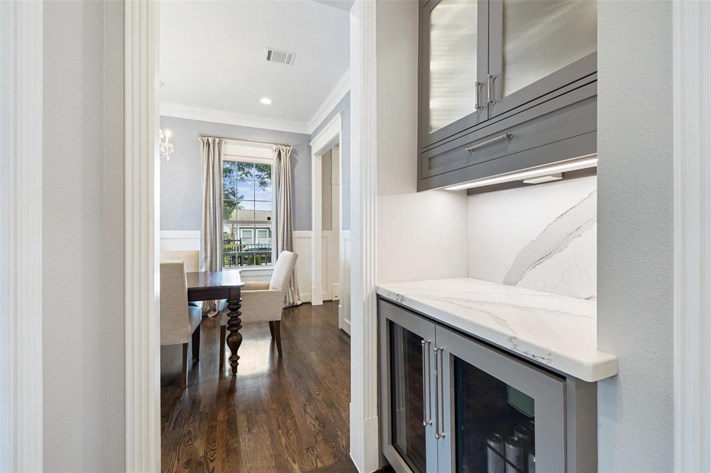This butler's pantry is located just off the dining room and kitchen. There is a built-in beverage fridge, Cambrian Quartz backsplash and countertops, and under cabinet lighting.