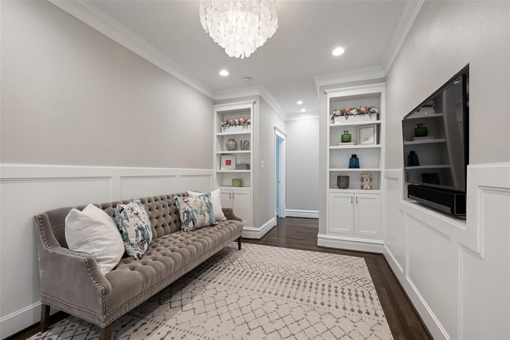This TV room/sitting area is located at the top of the stairs and it includes built-in TV with Sonos Bar, a Media cabinet, and built in bookshelves.