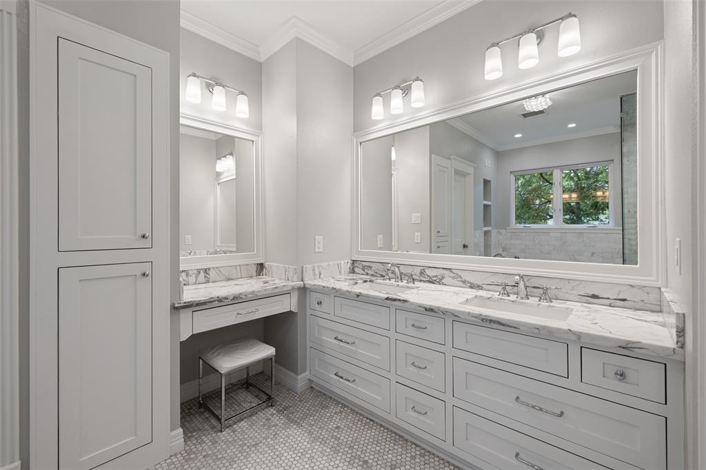 The master bathroom also includes double sink vanity, custom cabinetry with recessed doors and drawers, and a separate makeup space. The walk-in closet is located just off the master bathroom and includes built-in cabinetry and tons of storage.